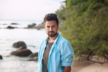 Portrait of a young attractive stylish male mixed race Hispanic man with a beard, outdoor