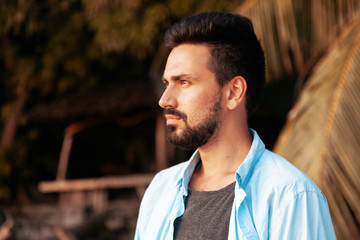 Portrait of a young attractive stylish male mixed race Hispanic man with a beard, outdoor