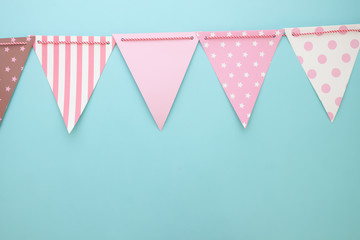Pastel colour bunting or party flags on blue background. Party or anniversary background