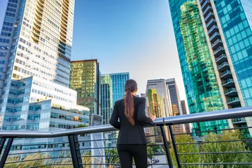 Foto op Plexiglas Toronto Zakenvrouw in het centrum kijken naar de skyline van wolkenkrabbers in het centrum van Vancouver, Canada. Zakenvrouw van achteren nadenkend over succes en toekomst in carrière en werk.