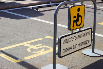 Parking space. Parking place signs for disabled The inscription in Russian and Kazakh languages: "Parking for the disabled"