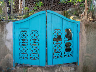 Old blue wooden double doors in a park.