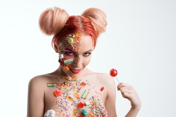 Girl with sweets on her face isolated shot