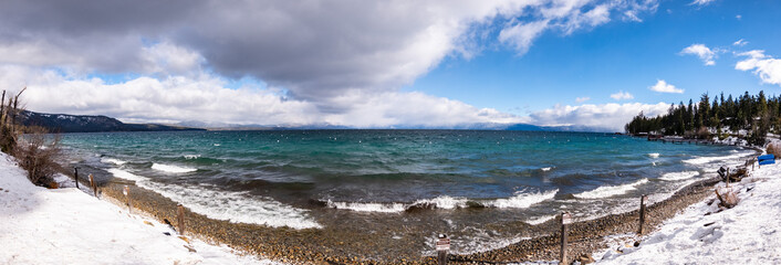 Sunny winter day on the shoreline of Lake Tahoe, Sierra mountains, California; breaking surf created by the wind; Private Property / No Tresspassing signs posted along the shoreline