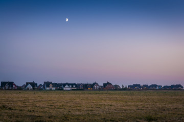 Fototapeta na wymiar Der Mond scheint über einem Dorf auf Insel Rügen am Abend