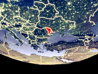 Satellite view of Moldova from space at night. Beautifully detailed plastic planet surface with visible city lights.