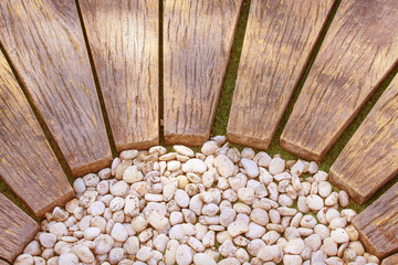 Brown wood walkway with white small rocks pattern in the garden,Natural background top view