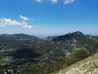 Fototapeta na wymiar Mountain peaks and clouds in the sky. Montenegro Sunny summer day, windless weather.