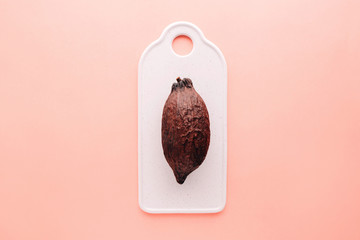 Cocoa pod on a pink background, creative flat lay food concept