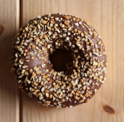 Hazelnut chocolate donut on wood background. Top view. Delicious food.