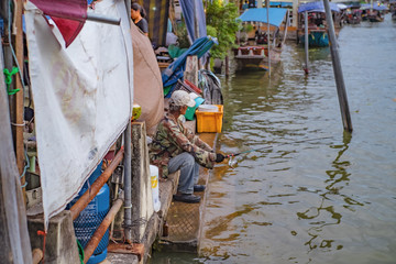 Unacquainte thai people Fishing on the river in Amphawa Floating market in holiday time.Amphawa Floating market is very Famous Street food travel destination in thailand