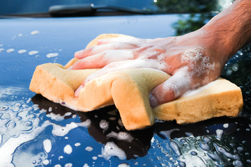 man washes a car