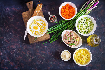 Ingredients for preparation salad of cod liver with eggs, cucumbers, potatoes and carrot in a bowls. Top view