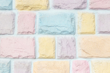 Colorful pastel brick wall texture background. Pink, yellow, orange purple and blue.