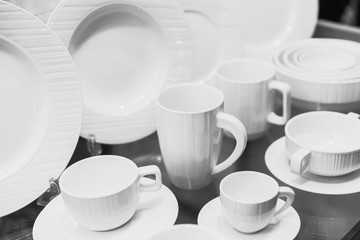 Set of clean white ceramic tableware dish and cups.