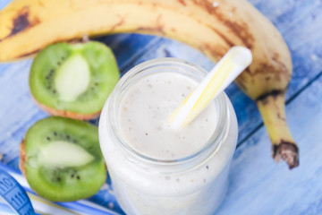 kiwi Banana smoothie with honey and oats on a wooden table.