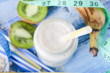 kiwi Banana smoothie with honey and oats on a wooden table.