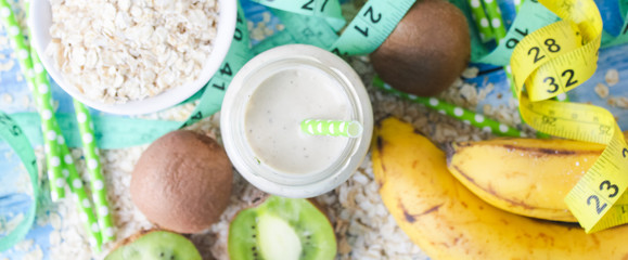 kiwi Banana smoothie with honey and oats on a wooden table.