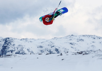 Naklejka na ściany i meble Professional kite boarding rider sportsman with kite in sky jumps high acrobatics kiteboarding trick with grab of kiteboard. Recreational activity, extreme active sports, snowkiting ski snowboard
