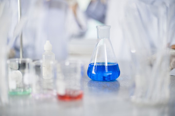 Chemistry laboratory glassware containing chemical liquid preparation - Blue liquid glass