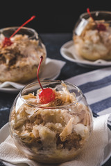 Tasty sweet dessert Napoleon cake with cocktail cherry in a glass bowl. Closeup