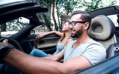 young man sitting behind the wheel of a luxury car.