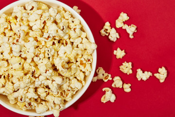 Full of popcorn in bowl on color background