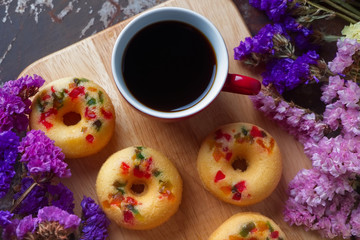 Fruity donuts with cup of black coffee