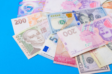 Close up on pile of many bank notes from various countries from around the world. U.S., German, Swiss, Canadian, Brazilian, Vietnamese, Mexican. Many countries represented in currency. 