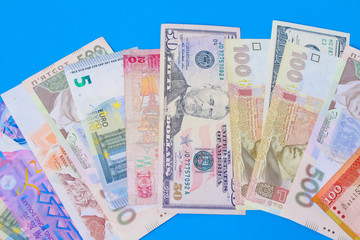 Close up on pile of many bank notes from various countries from around the world. U.S., German, Swiss, Canadian, Brazilian, Vietnamese, Mexican. Many countries represented in currency. 