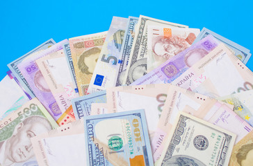 Close up on pile of many bank notes from various countries from around the world. U.S., German, Swiss, Canadian, Brazilian, Vietnamese, Mexican. Many countries represented in currency. 