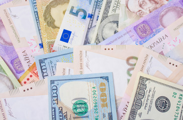 Close up on pile of many bank notes from various countries from around the world. U.S., German, Swiss, Canadian, Brazilian, Vietnamese, Mexican. Many countries represented in currency. 