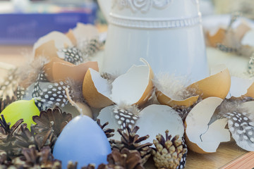 eggs shell and feathers on a table. Easter holidays decoration