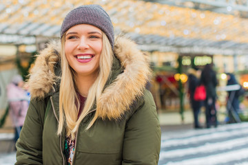 Portrait of attractive happy plus size young model in parka jacket casual style walk at city at winter day . Life of xl woman