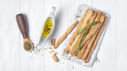 Top view of traditional italian appetizer grissini with rosemary spice and olive oil