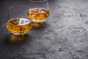 Two glasses of Cognac with ice cubes