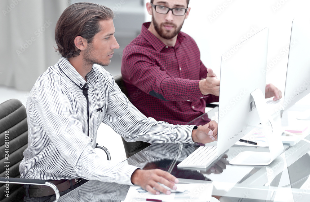 Poster Two employees , sitting in front of computer