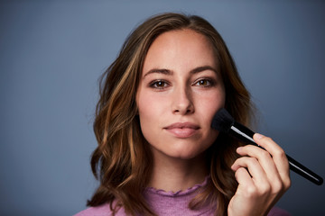 Beauty with make-up brush, portrait