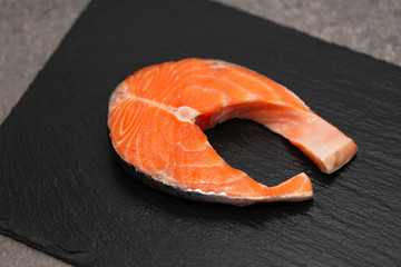 Fresh Raw Salmon Red Fish Steak on a black slate plate