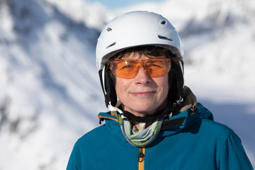 Senior Skifahrerin mit Helm und Brille auf der Skipiste