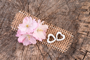 Valentines Day background with pink cherry - flowers. Valentines card with heart, old wooden background.  