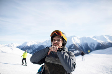Fototapeta na wymiar Junger Mann mit Snowboard Skihelm und Skibrille