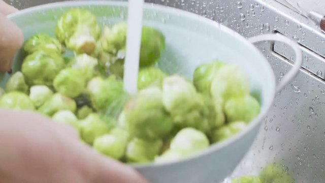 washing raw Brussels sprouts in kitchen sink
