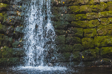 small decorative waterfall on a stone wall