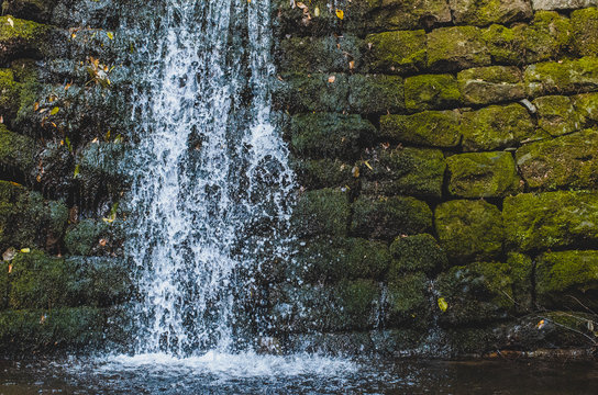 small decorative waterfall on a stone wall © Максим Галінский