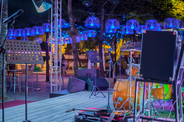 modern concert stage with musical instruments, bright neon lights,