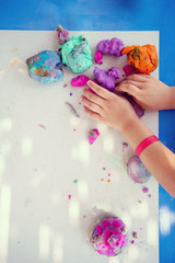 kid hands Playing with Colorful Clay