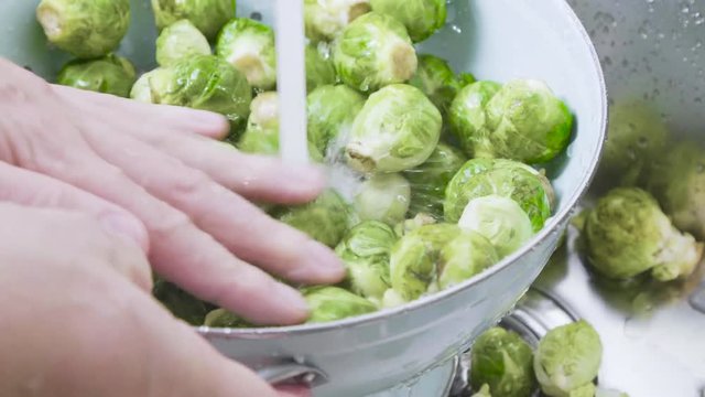 washing raw Brussels sprouts in kitchen sink