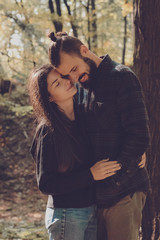 View of couple embracing in woods: couple of lovers of people, husband and wife or a boy and girl during a date or walks in the woods