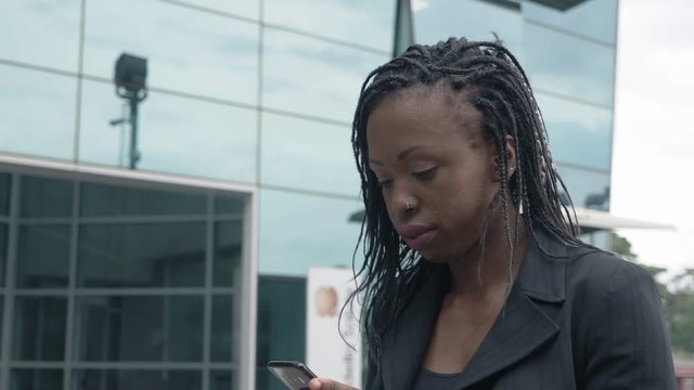 Thoughtful worried young black businesswoman walking thinking-slow motion